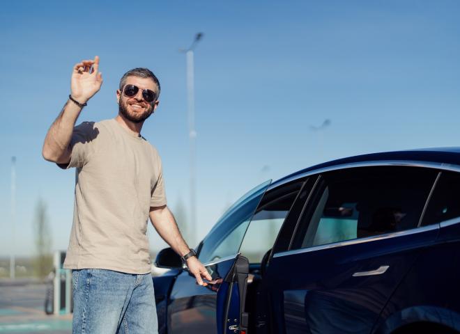 Un homme en train de recharger une voiture électrique
