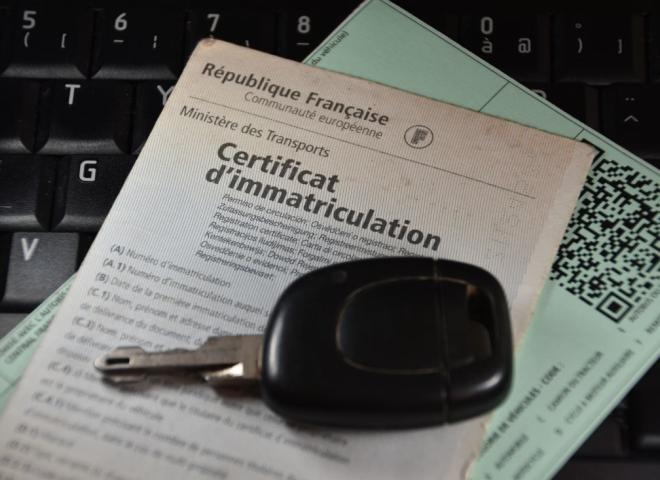 Une carte grise et des clés de voitures