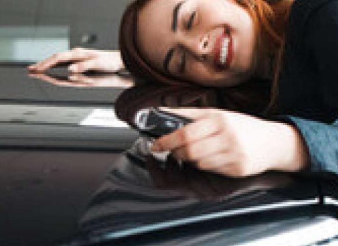 Une femme fait un câlin à sa voiture d'occasion car elle a trouvé son financement