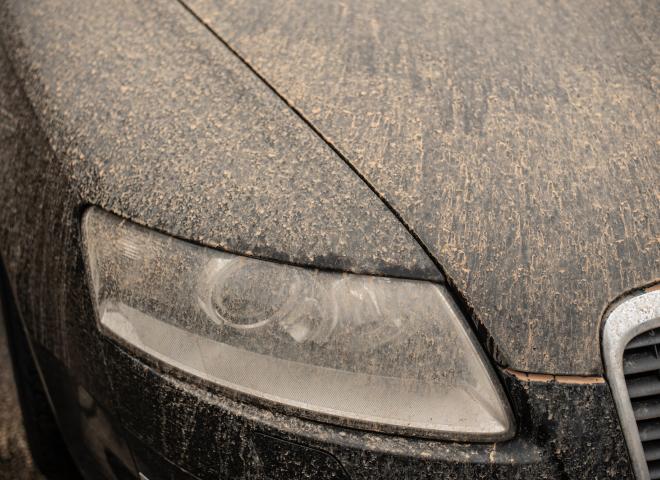 Un capot et une optique de phare recouverts de sable du Sahara
