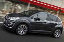 Une Citroën C3 d'occasion noire d'ancienne génération roulant en ville