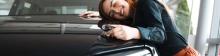 Une femme fait un câlin à sa voiture d'occasion car elle a trouvé son financement