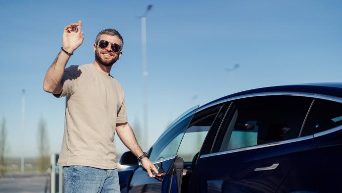 Un homme en train de recharger une voiture électrique