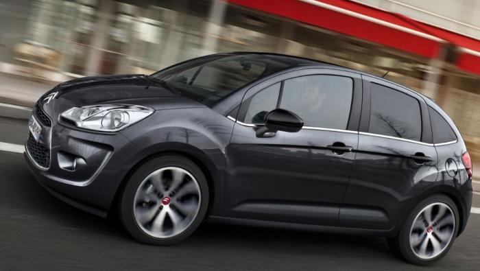 Une Citroën C3 d'occasion noire d'ancienne génération roulant en ville