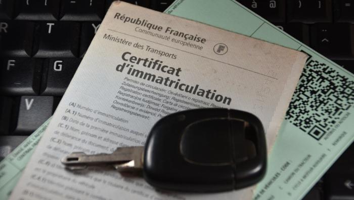Une carte grise et des clés de voitures