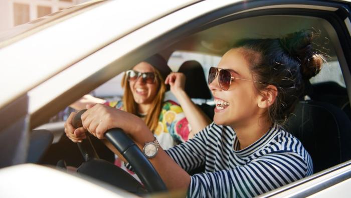 Jeune conductrice au volant de sa voiture d'occasion