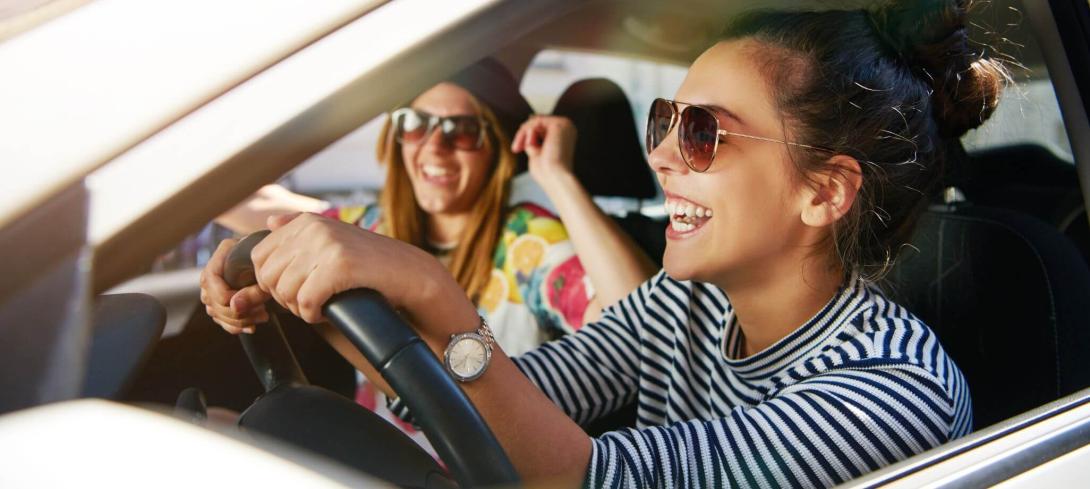 Jeune conductrice au volant de sa voiture d'occasion